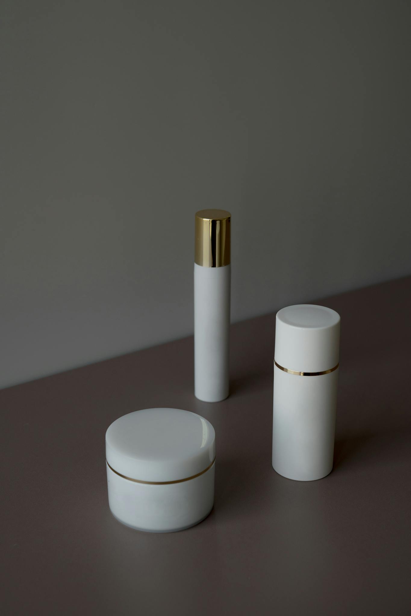 Elegant minimalist shot of skincare product containers with a gray background.
